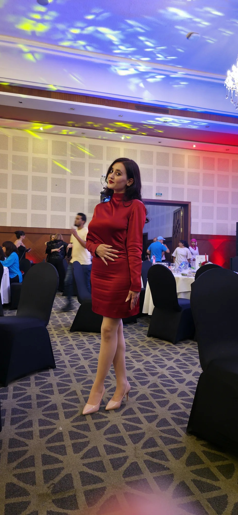 HASNAE T en robe rouge dans une salle de réception